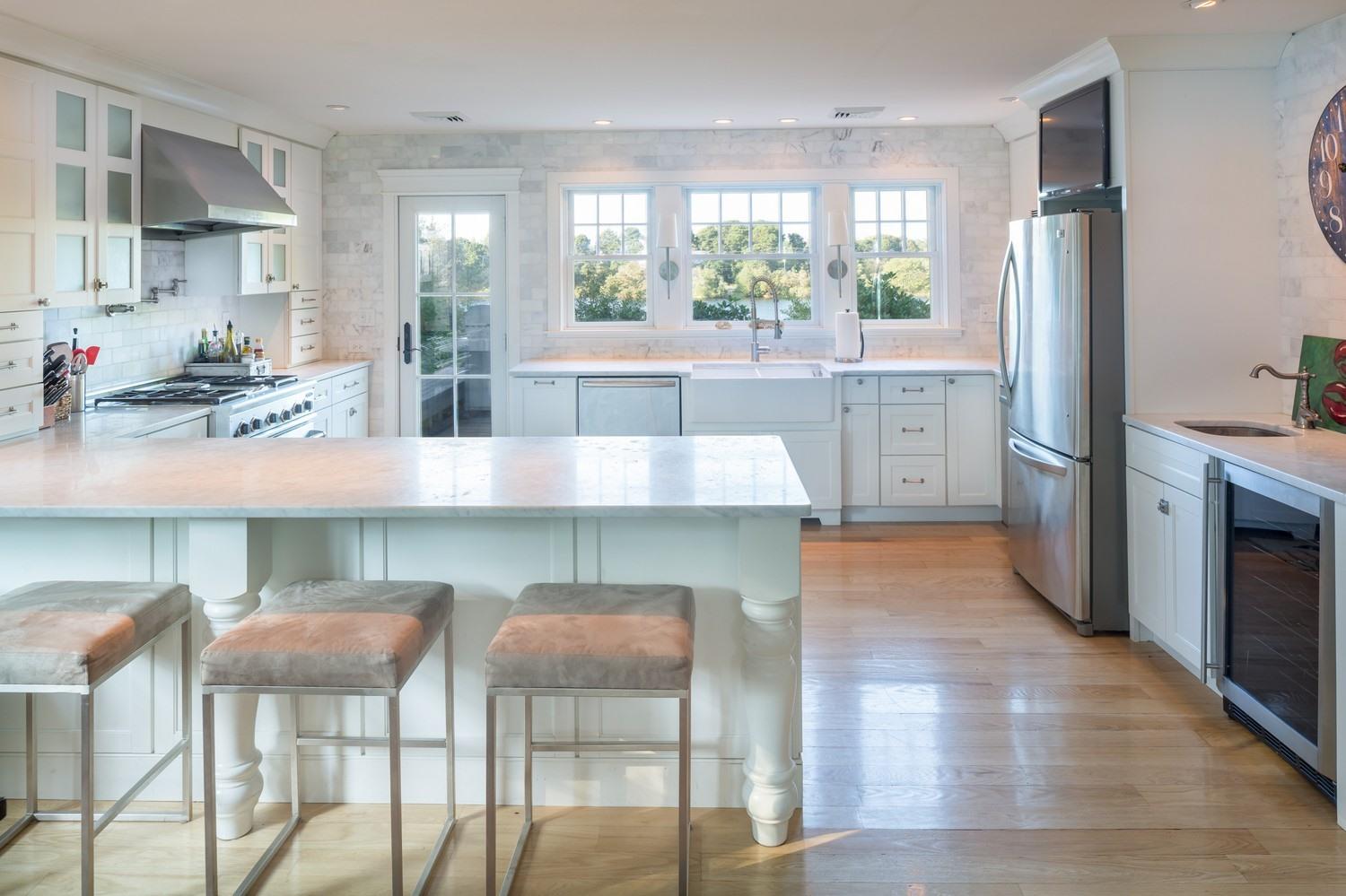 721 Samoset Road Eastham, MA 02642 - Photo 23 of 32 a kitchen with stainless steel appliances granite countertop a table chairs stove and refrigerator