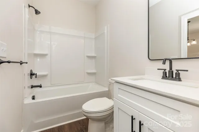 a bathroom with a sink toilet vanity and shower