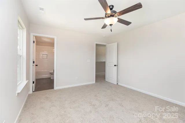 an empty room with chandelier fan
