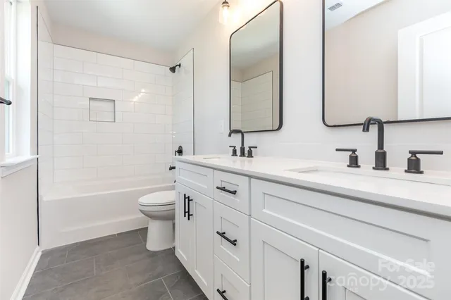 a bathroom with a double vanity sink mirror double and a bathtub