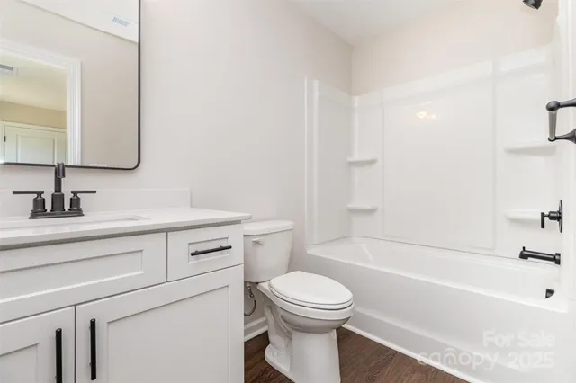 a bathroom with a toilet a sink a mirror and bathtub