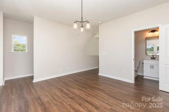 a view of a room with wooden floor and a ceiling fan