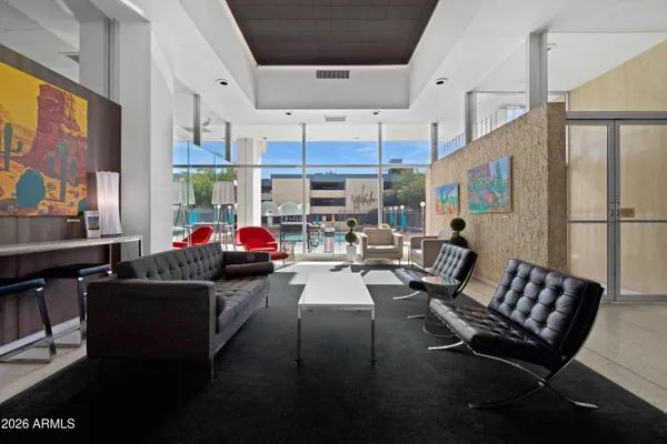 a living room with furniture kitchen view and a large window