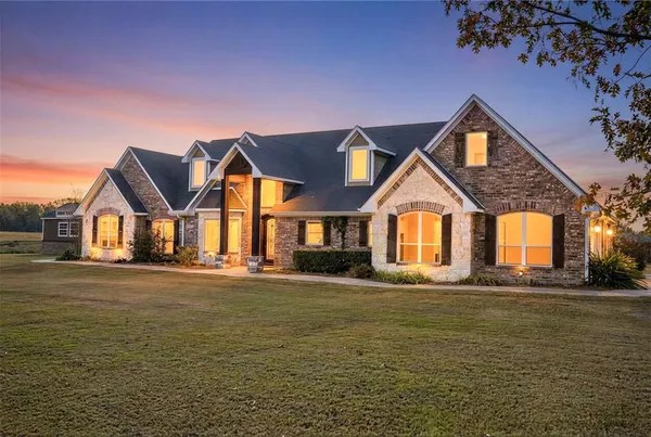 a front view of a house with a yard and lake view