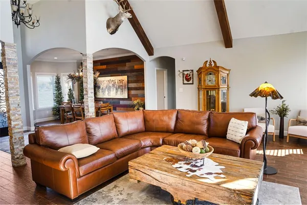 a living room with furniture flowerpot and a chandelier