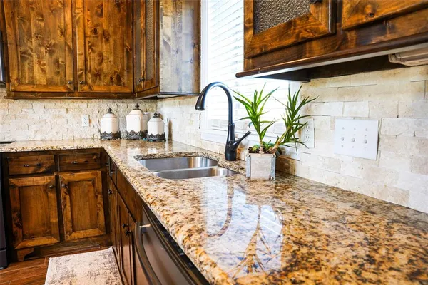 a kitchen with granite countertop a sink and a stove
