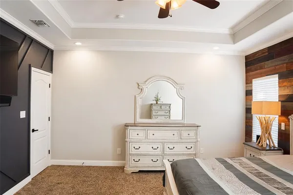 a view of a hallway with closet and a chandelier fan