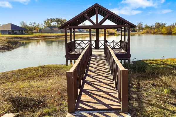 a view of a lake with wooden stairs and bridge and palm trees