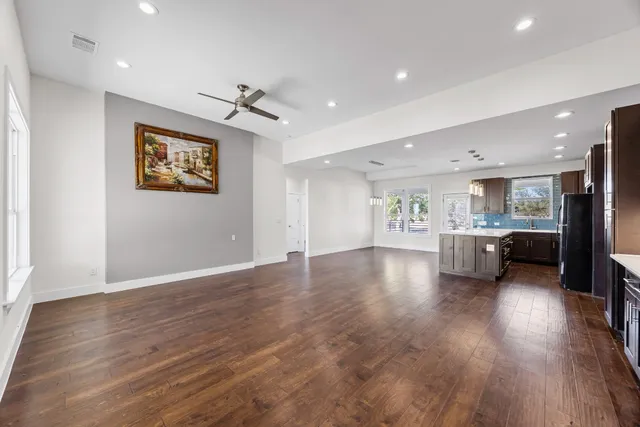 a view of a living room a kitchen and a wooden floor