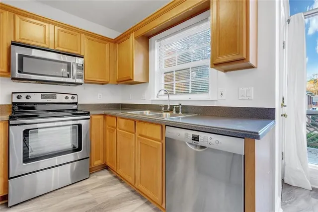 a kitchen with stainless steel appliances granite countertop a stove microwave and sink