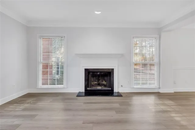 a view of an empty room with a window and fireplace