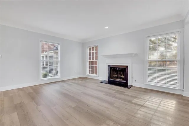 a view of an empty room with a window and fireplace