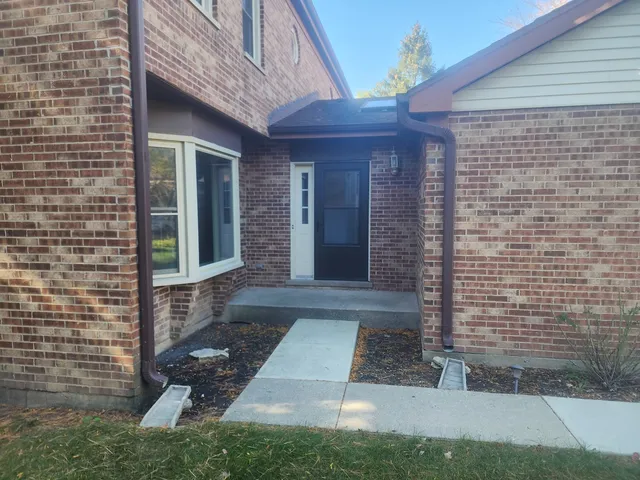 a view of brick house with a yard