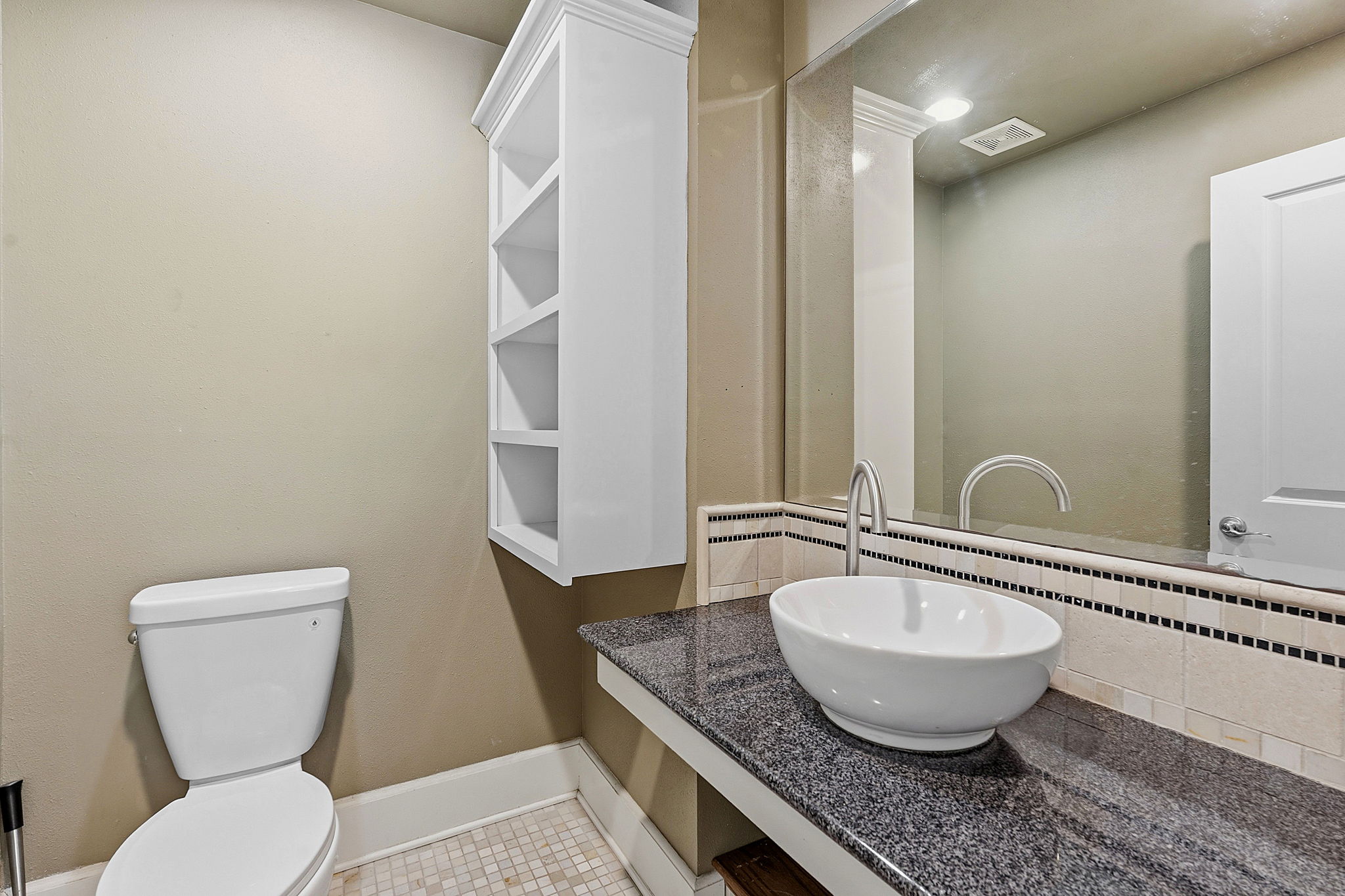 1305 Cometa Street Austin, TX 78721 - Photo 21 of 28 A well-appointed powder room features a vessel sink on a granite counter and a chic mirrored wall.