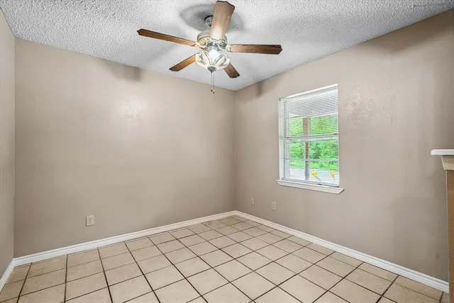 an empty room with windows and fan