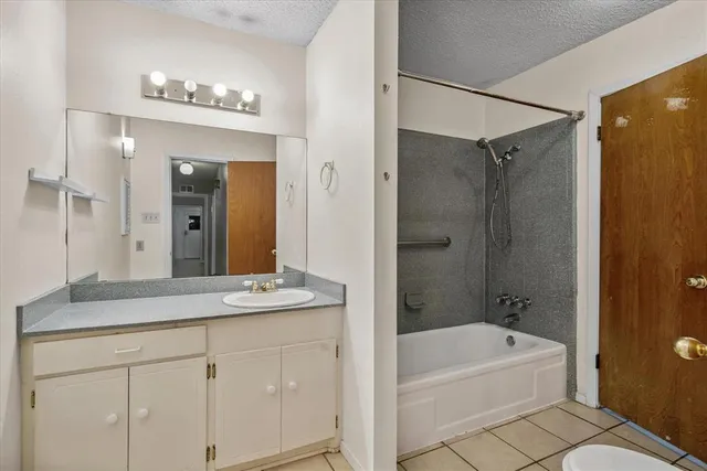 a bathroom with a sink double vanity granite tub shower and a mirror