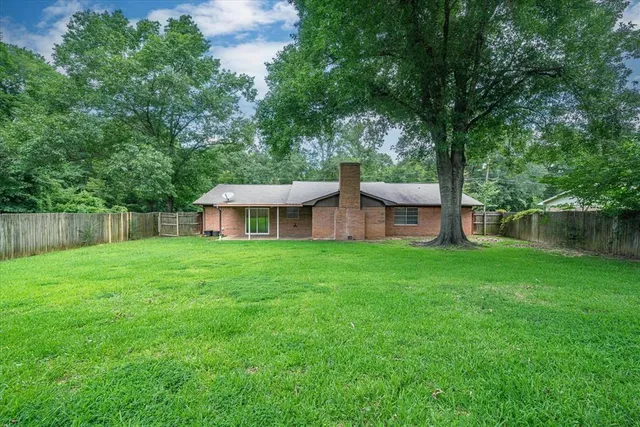 a view of a house with backyard sitting area and garden
