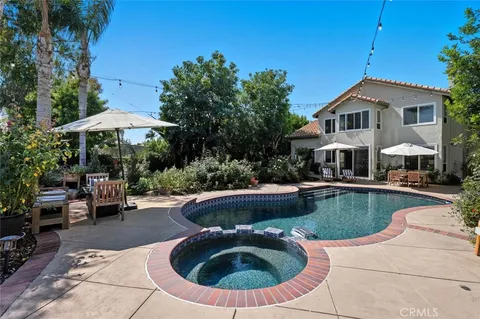 a view of a house with swimming pool and sitting area