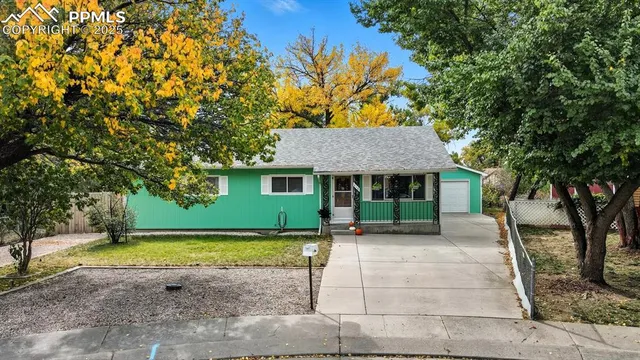 a front view of a house with a garden and tree