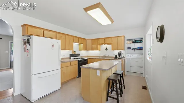 a kitchen with stainless steel appliances granite countertop a stove a sink dishwasher and a refrigerator