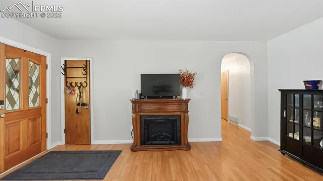 a view of a hallway with wooden floor and a bathroom