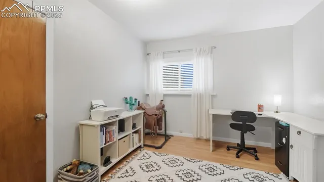 a view of a workspace with furniture and a window