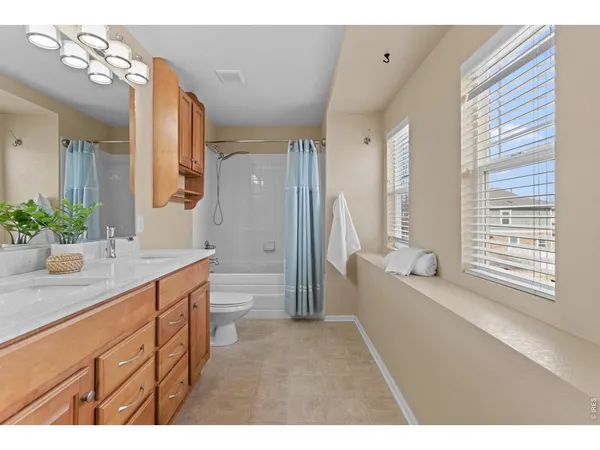 a bathroom with a granite countertop sink toilet a large mirror a shower and a bathtub