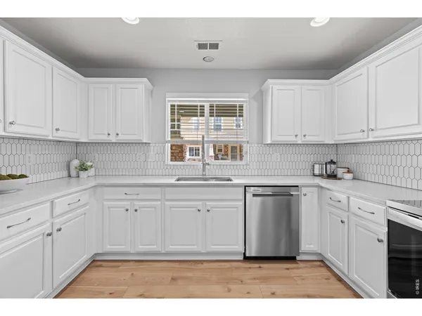 a kitchen with cabinets and chairs