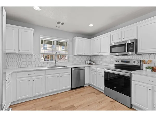 a kitchen with granite countertop a sink stainless steel appliances and cabinets