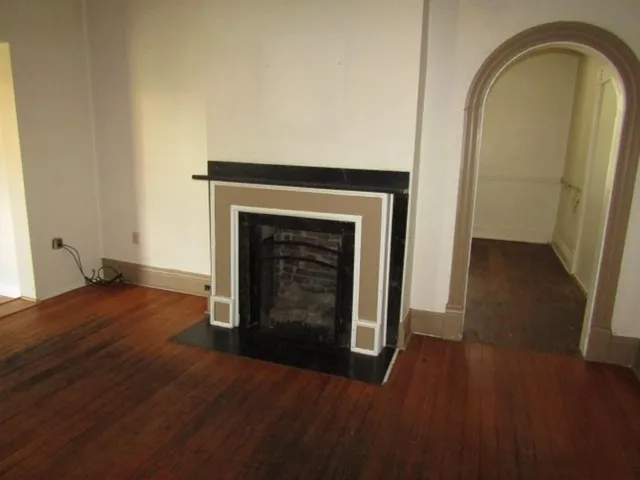 a view of empty room with wooden floor and fireplace