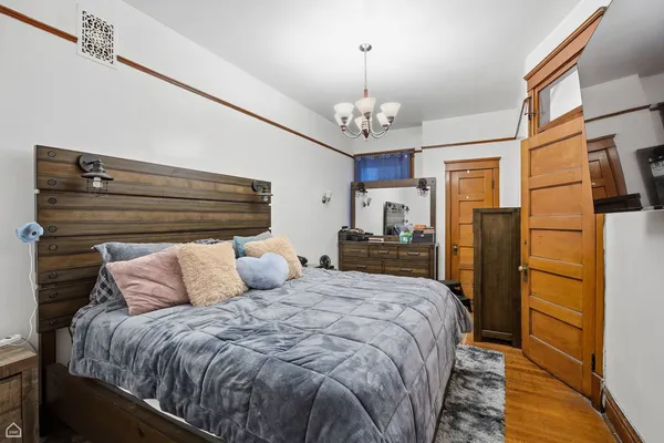 a spacious bedroom with a bed and wooden floor