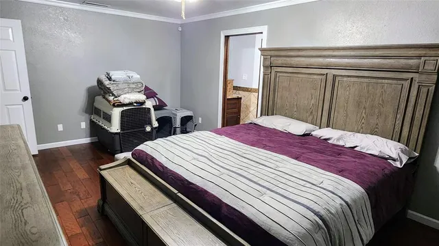 a bed sitting in a bedroom and wooden floor