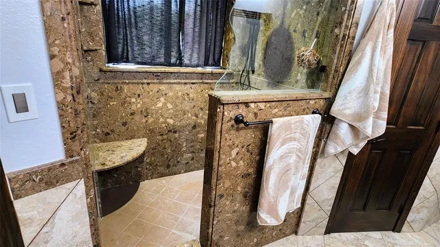 a bathroom with a granite countertop shower a sink and a mirror