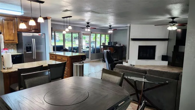 a kitchen with a table chairs refrigerator and fireplace
