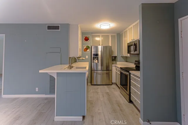 a kitchen with a sink appliances and cabinets