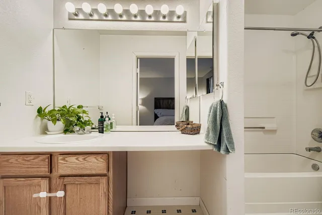 a bathroom with a granite countertop sink a toilet and shower