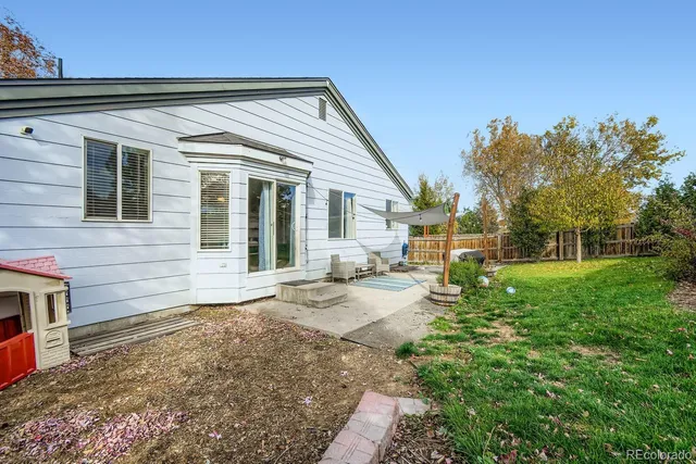 a view of a house with backyard and sitting area