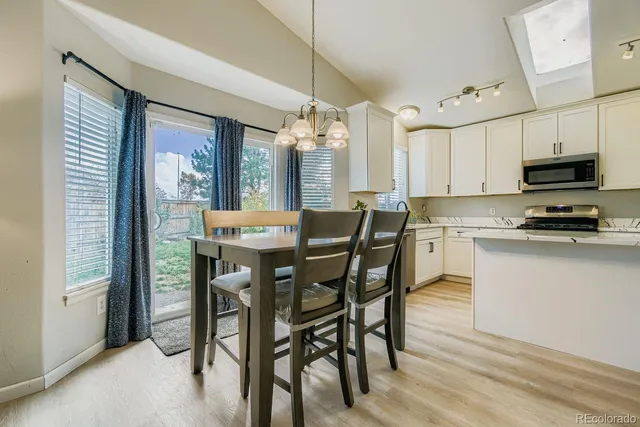 a kitchen with a table chairs sink and cabinets