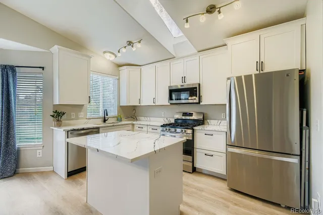 a kitchen with white cabinets and white stainless steel appliances