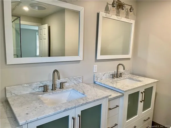 a bathroom with a double vanity sink a mirror and a bathtub