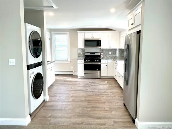 a kitchen with stainless steel appliances granite countertop a stove a sink and a refrigerator