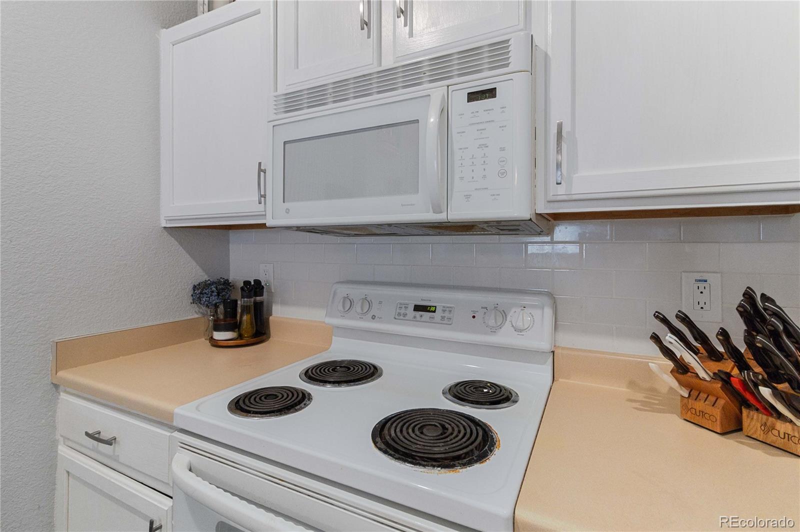 5255 Memphis Street, Unit 702 Denver, CO 80239 - Photo 10 of 30 a kitchen with a stove and white cabinets