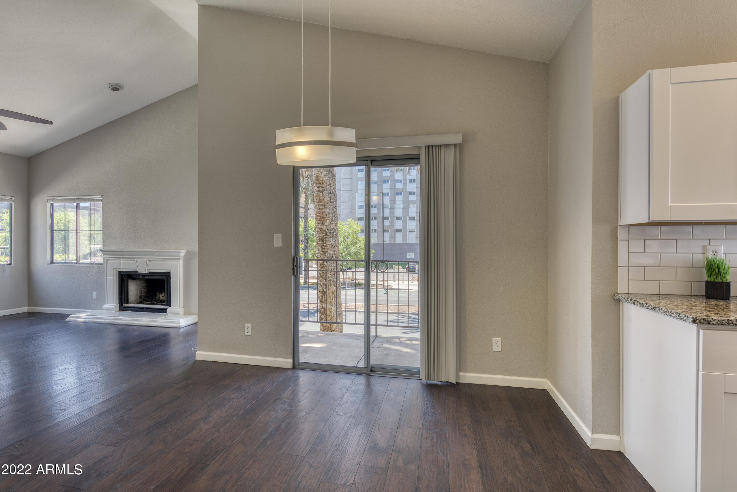 100 East Fillmore Street, Unit 201 Phoenix, AZ 85004 - Photo 11 of 23 an empty room with wooden floor fireplace and windows