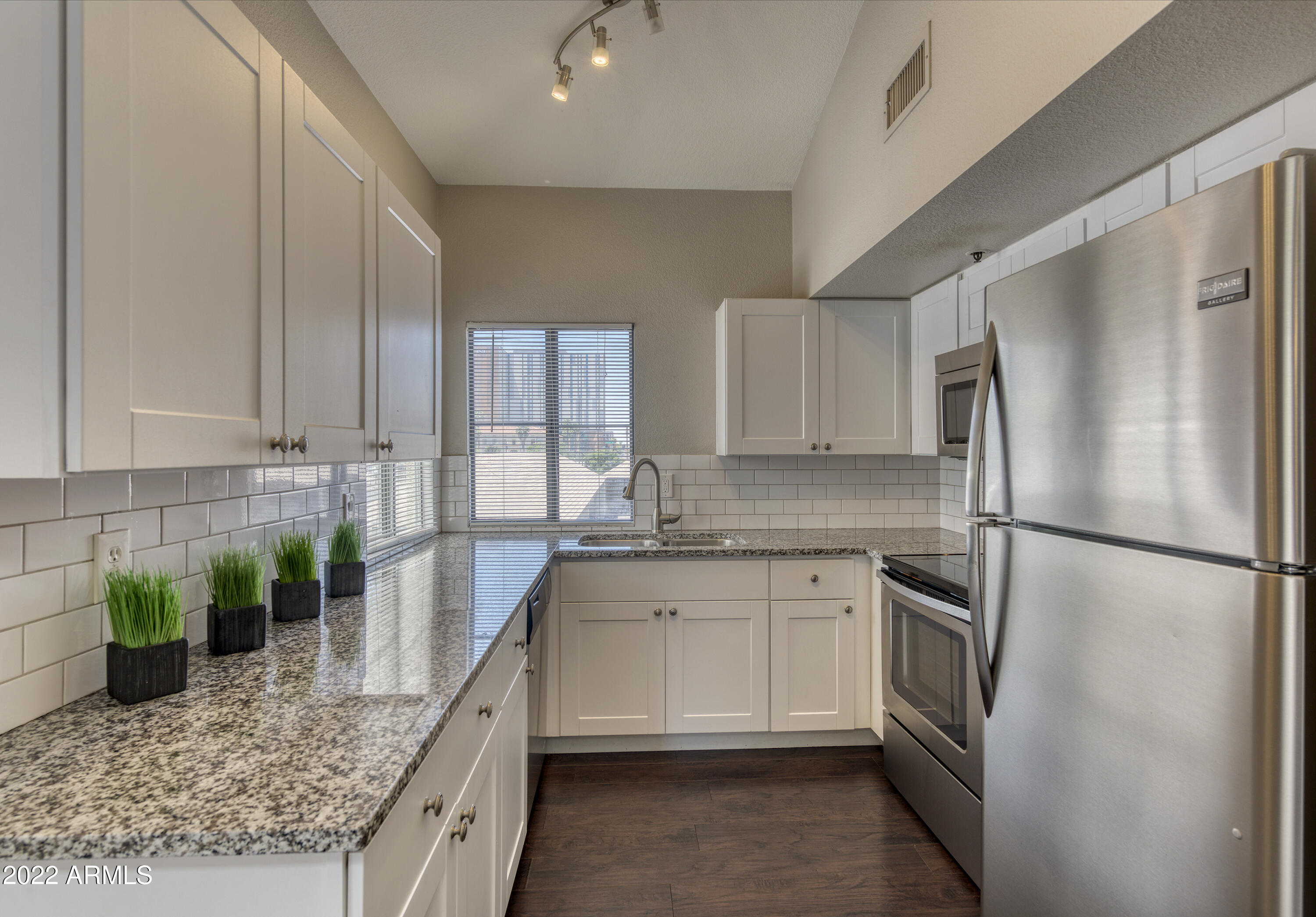 100 East Fillmore Street, Unit 201 Phoenix, AZ 85004 - Photo 12 of 23 a kitchen with stainless steel appliances granite countertop a refrigerator a sink a stove a washer and dryer
