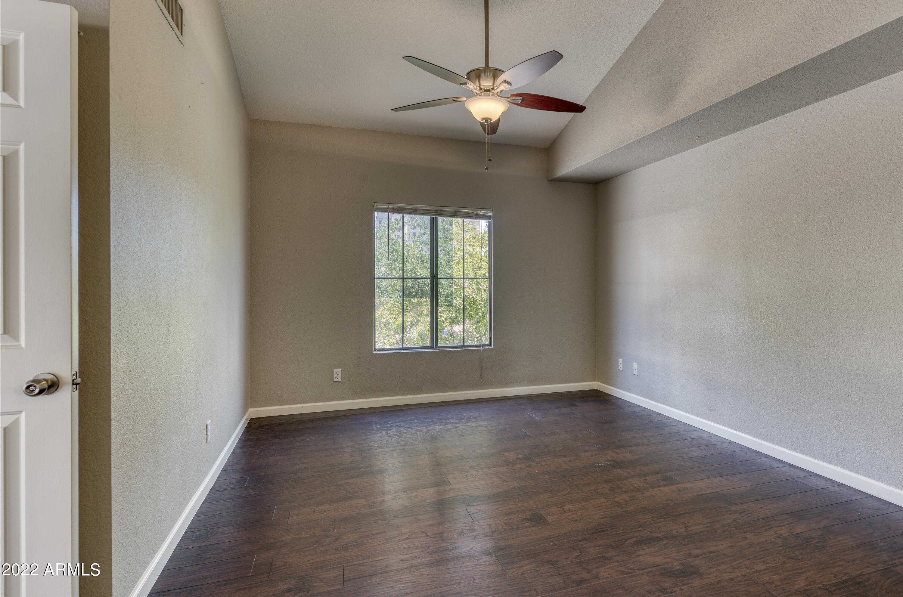 100 East Fillmore Street, Unit 201 Phoenix, AZ 85004 - Photo 14 of 23 an empty room with wooden floor chandelier fan and windows