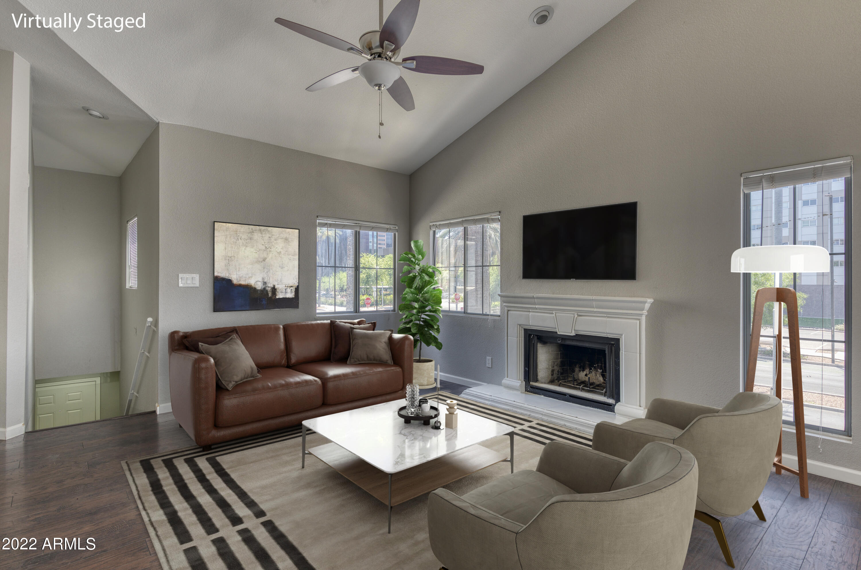 100 East Fillmore Street, Unit 201 Phoenix, AZ 85004 - Photo 3 of 23 a living room with furniture a fireplace and a flat screen tv