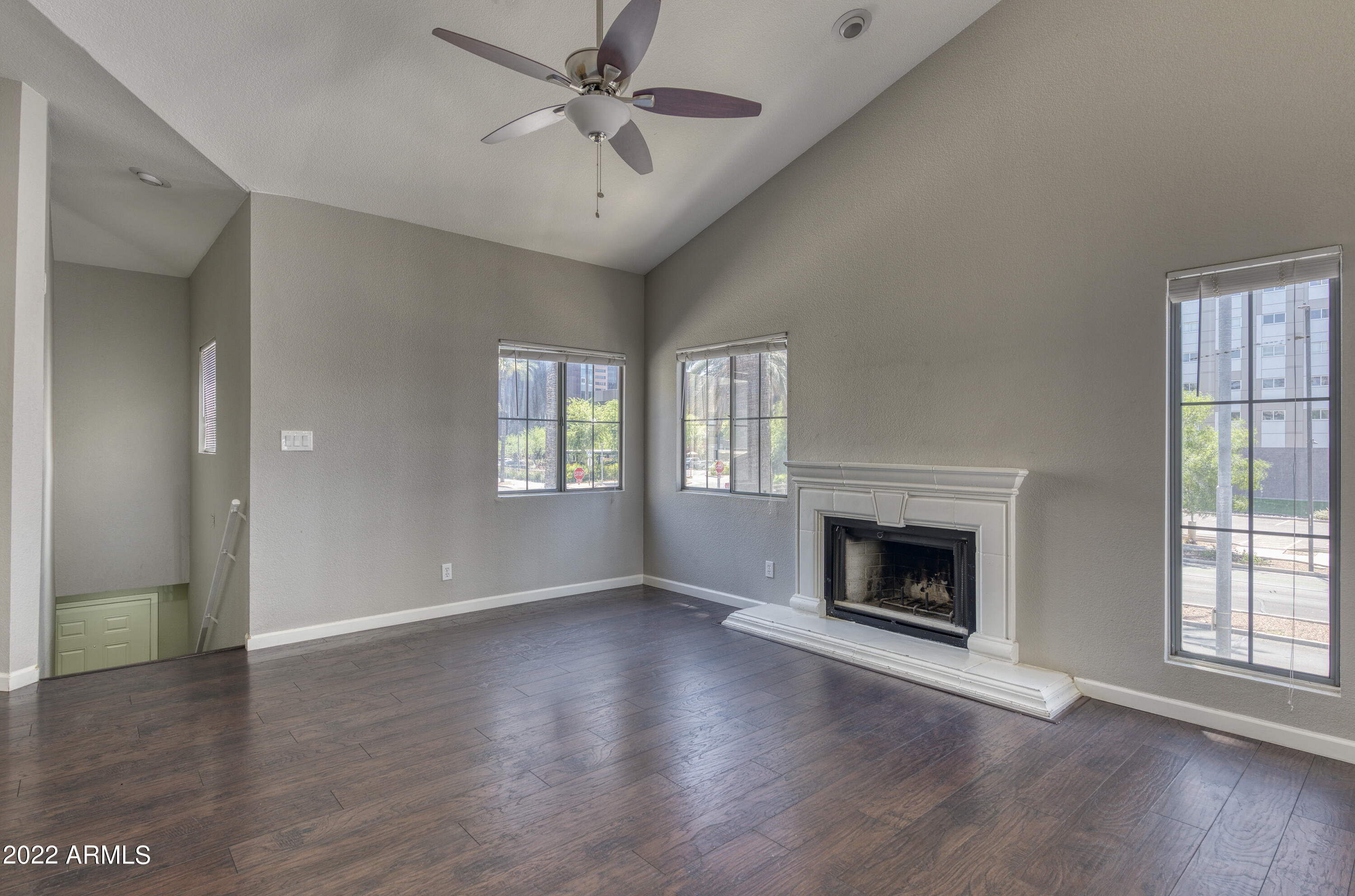 100 East Fillmore Street, Unit 201 Phoenix, AZ 85004 - Photo 7 of 23 an empty room with wooden floor a fireplace and windows