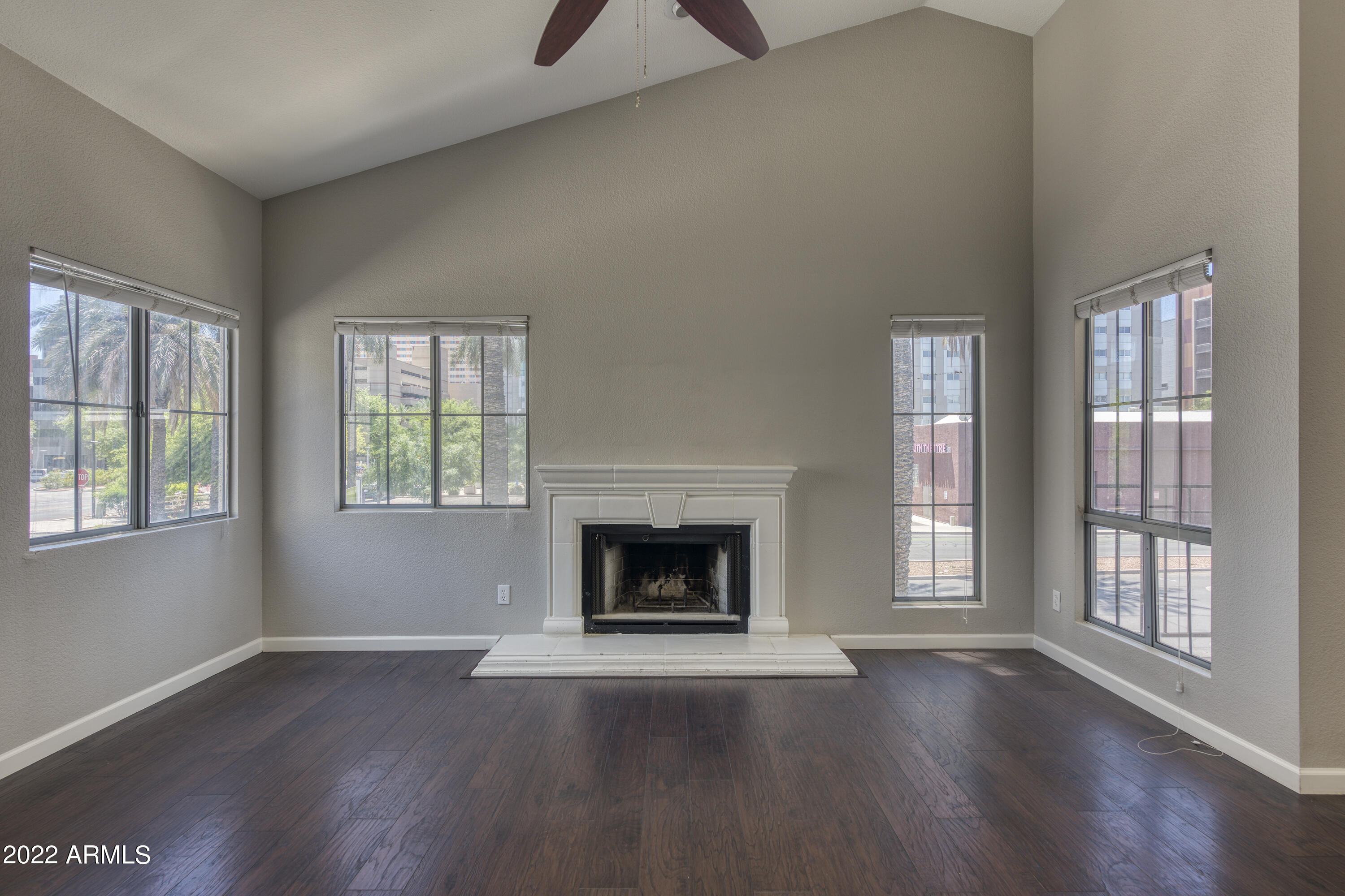 100 East Fillmore Street, Unit 201 Phoenix, AZ 85004 - Photo 8 of 23 an empty room with fireplace and wooden floor