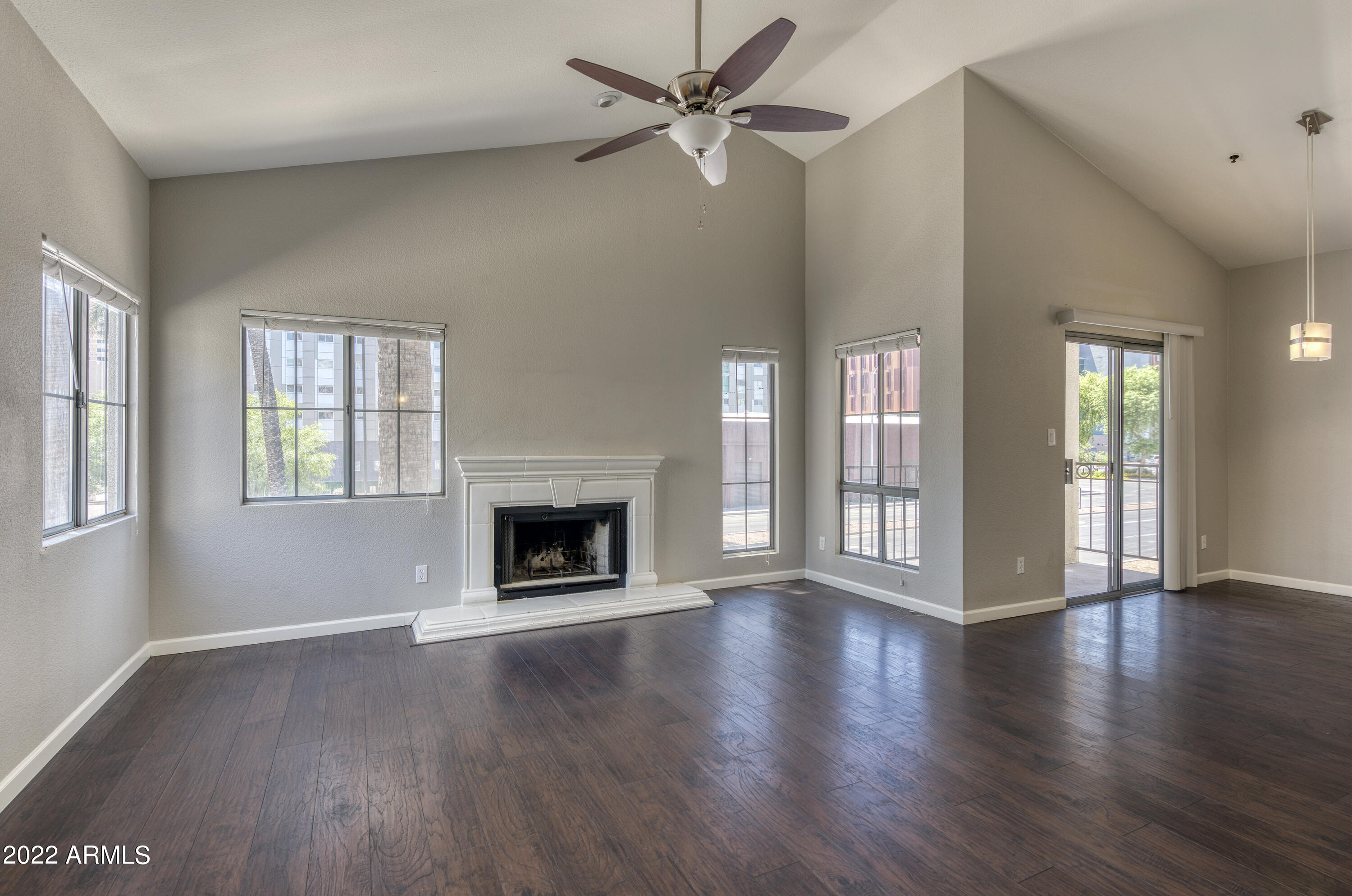 100 East Fillmore Street, Unit 201 Phoenix, AZ 85004 - Photo 9 of 23 an empty room with wooden floor a fireplace and windows