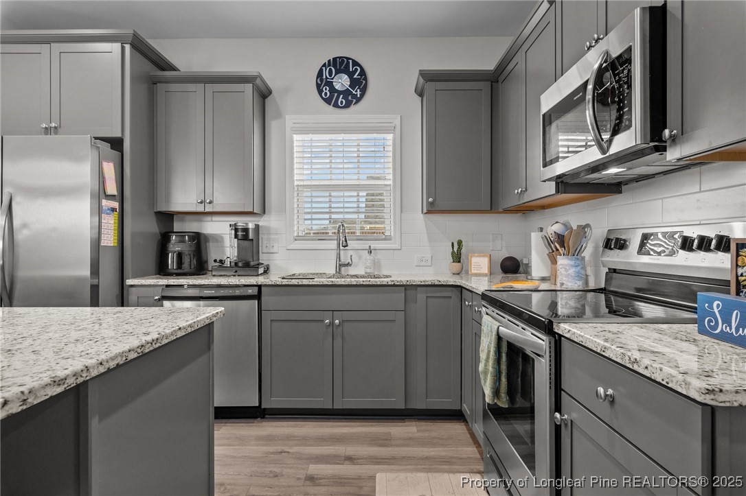 1660 Stackhouse Drive Fayetteville, NC 28314 - Photo 15 of 44 a kitchen with stainless steel appliances granite countertop a sink stove microwave refrigerator and cabinets